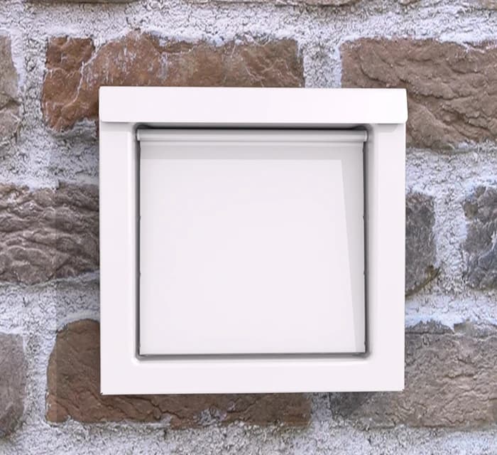 White square plastic exterior wall vent cover with a single flap on a brick wall.