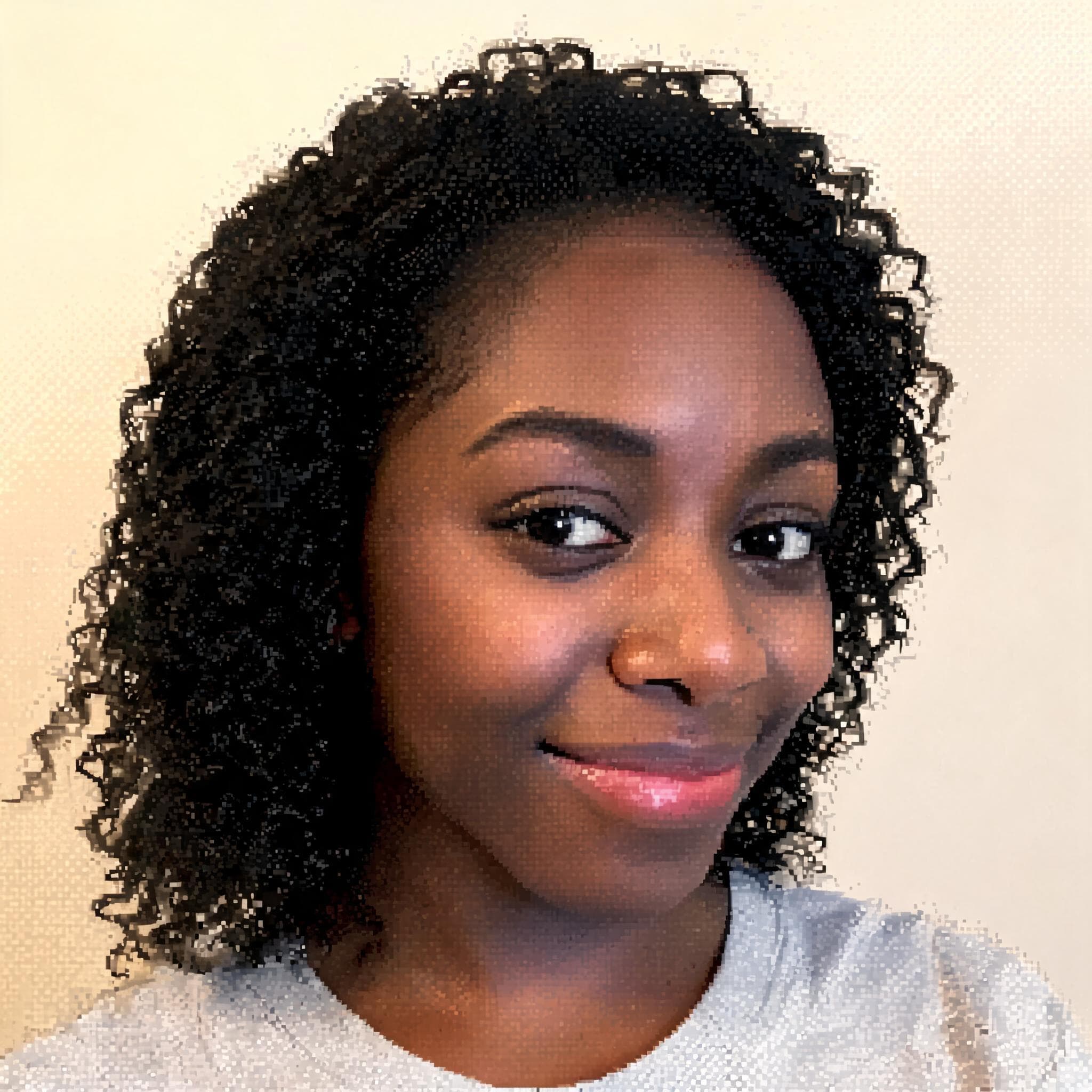 Smiling young Black woman with dark curly hair posed against a light neutral background.